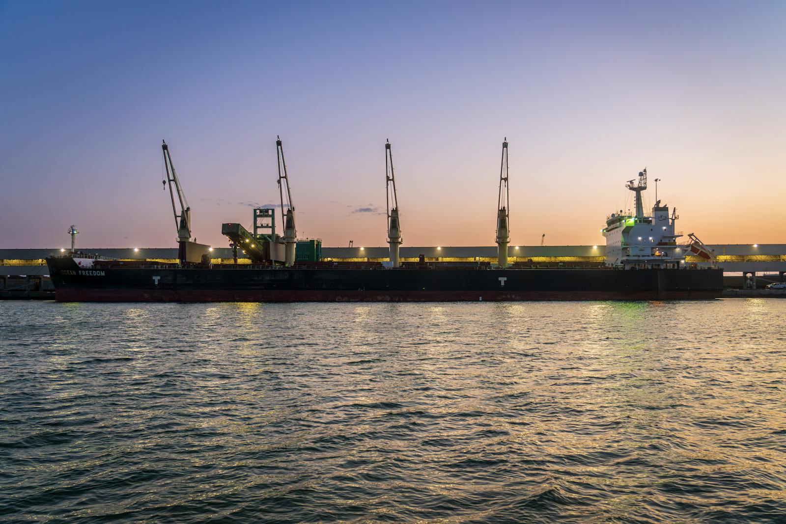 Bulk carrier at port at sunset